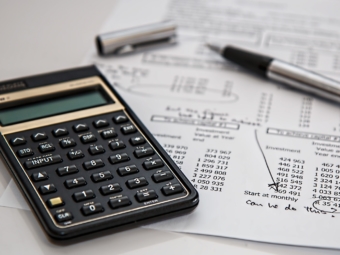 black-calculator-near-ballpoint-pen-on-white-printed-paper-53621